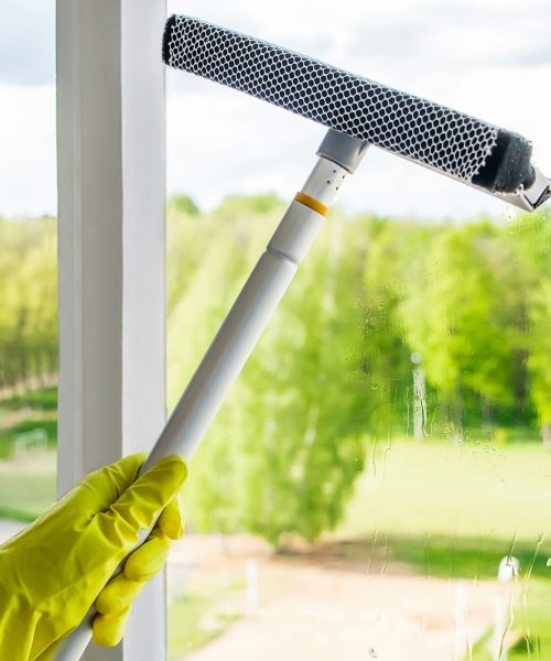 Window washing and home cleaning. Woman sprays a detergent on a glass. Housework concept. Window washing and home cleaning. Woman sprays a detergent on a glass. Housework concept.